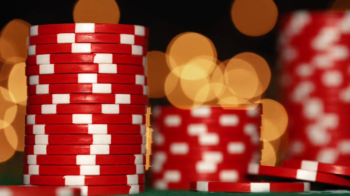 Tall stacks of poker chips on a green table, cover image for the Fiverr poker bot market article